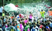A foam machine sprays students who gathered to listen to music at the ATO fraternity Saturday afternoon during the annual Block Party in Bloomsburg.
