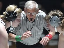 With a wave of his hand, wrestling referee Joe Cesari, center, starts a 285-pound match between Mifflinburg’s Cadyn Huffman, left, and Central Columbia’s Aiden Hidlay earlier this season at Central Columbia. The moment also marked the start of Cesari’s 50th year as a PIAA official.