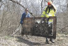 Joanne Osborne and Tanya Nebroski, top photo, remove a metal door from the woods along Creek Road in Hemlock Township on Sunday during the first Bloomsburg Community Creek Cleanup of the year. Nebroski organized the group last year.