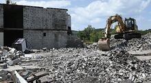 Earthwork Services’ excavators, photo at right, fill the old pool with rubble to allow for an easier route to bring down the last section of the Days Inn Friday afternoon in Danville.