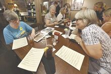 Lisa Coyne, left, looks through a photo book across from Deb Lehman at the Turkey Hill Brewing Company’s Purple Plate dinner, a time when the restaurant closes its first floor to the general public so dementia families can dine at their own pace -- and eat without worrying about possible outbursts offending staff or other patrons.