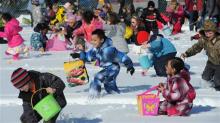 Kids collect eggs in several inches of snow Sunday in Anchorage, Alaska.