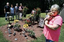 Judy Evans, at home in Almedia and holding a family dog named Little Guy, stands by her memorial garden to her great-grandson, Tyler Evans, on Friday. Standing are family, from left, brother Terry Hopper; niece Denise Hopper; and brothers Robert Hopper and Jerry Hopper.