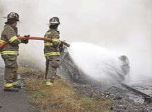 Catawissa firefighters douse a fully engulfed Toyota Corolla after it erupted in flames on railroad tracks along Route 42 near Rupert Wednesday morning after police say it struck the rock wall in the Catawissa Narrows.