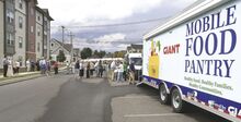 The Mobile Food Pantry and the new Mini Mobile Food Pantry are parked off West Sixth Street among the new apartment buildings in Bloomsburg during the celebration Thursday.