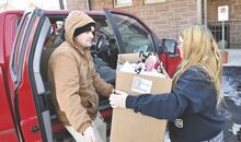 Chris Starr, at left, gets a box of items from Sydney Campbell Tuesday during the Bloomsburg Salvation Army's Angel Tree giveaway.