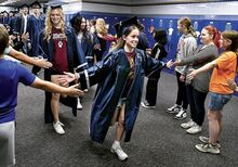 Central Columbia senior Abigail Twiddy, above, offers high-fives as she walks among fifth graders in Central Columbia Middle School during the Central Columbia and Columbia-Montour Vo-Tech senior walk through of their old school Tuesday.