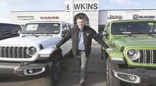 Josh Hawkins, president of Hawkins Chevrolet, stands between two Jeeps at Hawkins Chrysler, Dodge, Jeep and Ram along Route 11 in Cooper Township after the company recently bought out Kaiser Brothers.