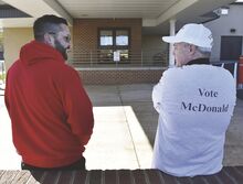 County judge candidates David James, left, and Anthony McDonald, right, talk while campaigning at the Bloomsburg Fire Hall on Wednesday.