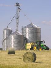 A farmer picks up rows of hay and makes large round bales out of it along Danville Road in Jerseytown Wednesday afternoon.