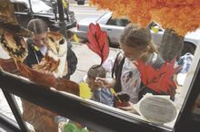 Columbia County Christian School students use the front window of the JAG Housing office along East Main Street in Bloomsburg as a canvas for painting Wednesday. From left are Sophie Gemberling, Elianna Engo and Emily Anstadt.