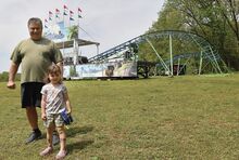 Mike Chorba and his granddaughter, Madilyn Gross, 5, stand by the Tidal Wave roller coaster Friday. Chorba has been restoring the ride at his Mount Pleasant Township home.