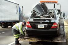 Joe Stigerwalt, from West End Towing, secures a damaged Toyota to a flatbed truck Wednesday morning. 