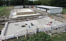 The concrete for the town’s wading pool, seen in the foreground, is nearly complete as work progresses on the site Wednesday in Bloomsburg.
