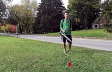 Ron Aikey stands across the road from his home at 78 Fort McClure Blvd. in Bloomsburg on Sunday afternoon. A small red flag in the foreground marks the proposed bike path that would cut through his property. The Aikeys say they were never contacted about the path in the town’s right-of-way.