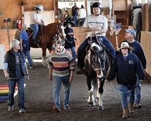 Volunteers and instructors walk with Matthew Zajac, on horseback in the foreground of the photo above. Colleen Bronson follows on her horse at the Eos Center outside of Buckhorn on Wednesday.