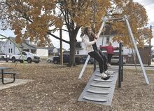 Kaya Mattern, 10, swings on Sponsler Park's new zipline Saturday during a celebration at the park as Freya Powell, 6, waits her turn.