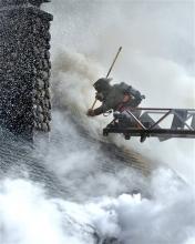 A firefighter from the McAdoo Fire Company Inc. is surrounded by smoke as he vents the roof during a fire at 887 Railroad Drive in Packer Township near Hazleton, Pa., on Wednesday, Nov. 13, 2013. The fire left a family of four homeless.