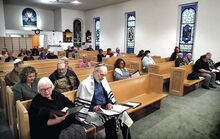 Members of the Beth Israel congregation and guests, above, observe Yom HaShoah, a day of remembrance of the Holocaust, in the Bloomsburg synagogue on Sunday evening.