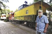 Railroad buff Walter Gosciminski stands by his Reading Railroad caboose at the Catawissa Railroad Station on Tuesday. He has collected 14 cabooses, which are placed in Catawissa and Rupert.  He may soon sell off his collection.