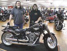 Brothers Ray, left, and Rich Vreeland stand by a Harley-Davidson Fat Boy in their showroom along Route 11, below Bloomsburg. Vreeland's Harley-Davidson will close at the end of the month.