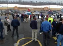 Walmart workers wait in a parking lot across Plaza Drive after the store was evacuated Friday afternoon for a bomb scare.
